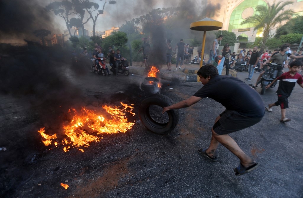 Lebanese youths burn tyres to block a main highway east of the capital Beirut, as they protest against the country's dire living conditions on 24 June 2021