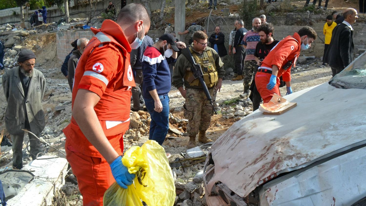 First responders search around a damaged car at the site of an overnight Israeli strike on Ain Yaacoub in Akkar, Lebanon on 12 November 2024.