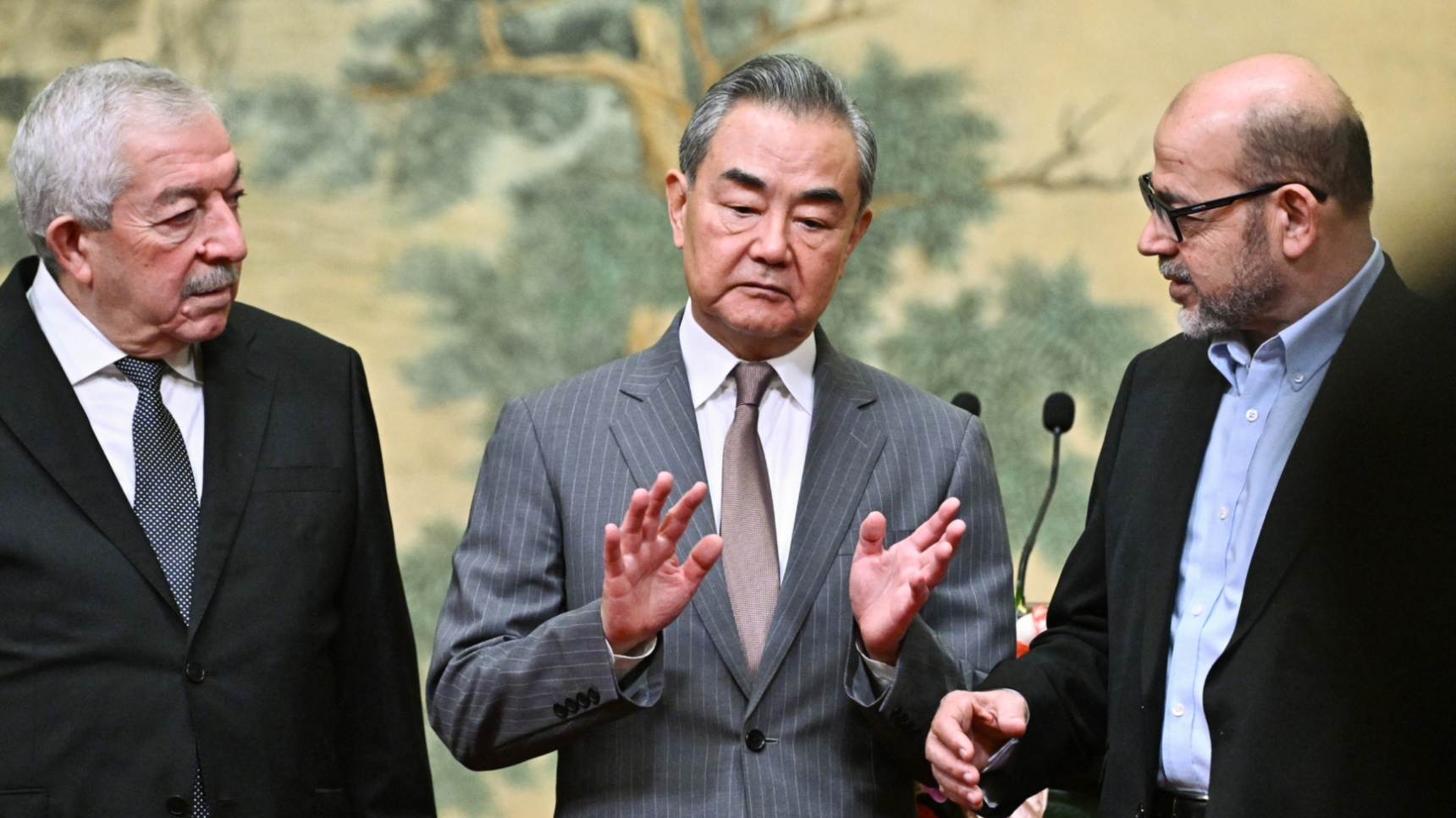 From left to right, Fatah's Mahmoud al-Aloul, Chinese Foreign Minister Wang Yi and Hamas's Mousa Abu Marzouk at an event at the Diaoyutai State Guesthouse in Beijing on 23 July, 2024 (Pedro Pardo/AFP)