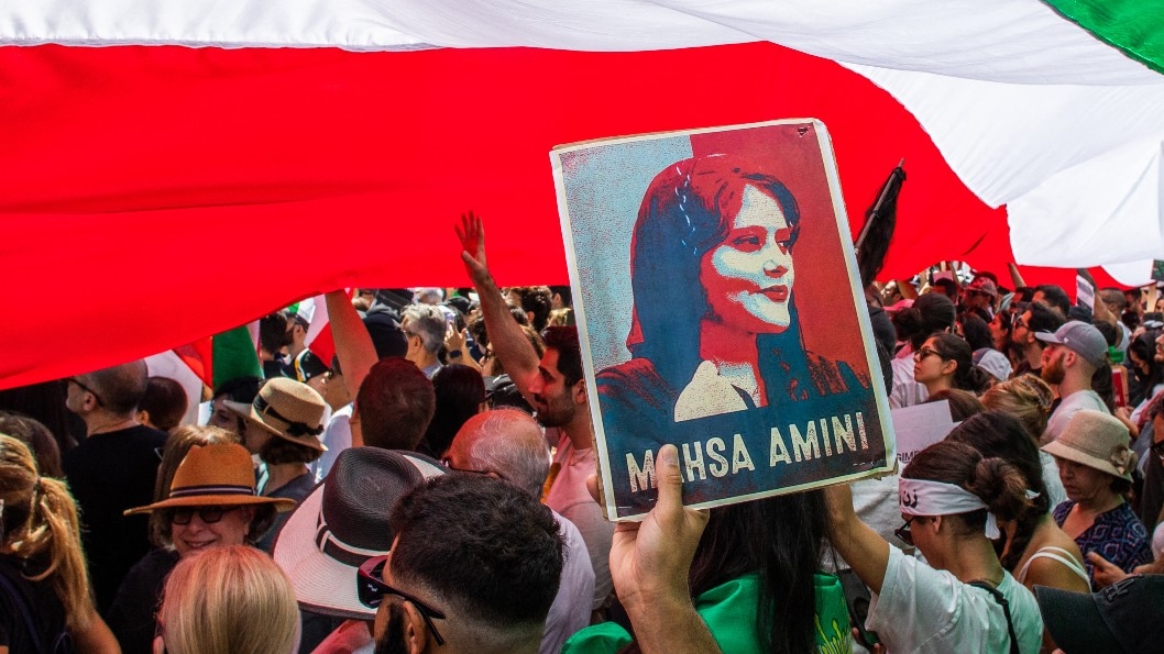 A demonstrator holds a picture Mahsa Amini as people march during a protest in Los Angeles, California, on 1 October 2022.