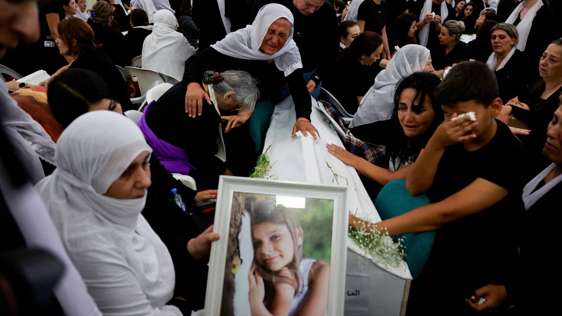 Families whose children were killed at a soccer pitch by a rocket launched across Lebanon's border with Israel react before the funeral in Majdal Shams on 28  July (Reuters/Ammar Awad).