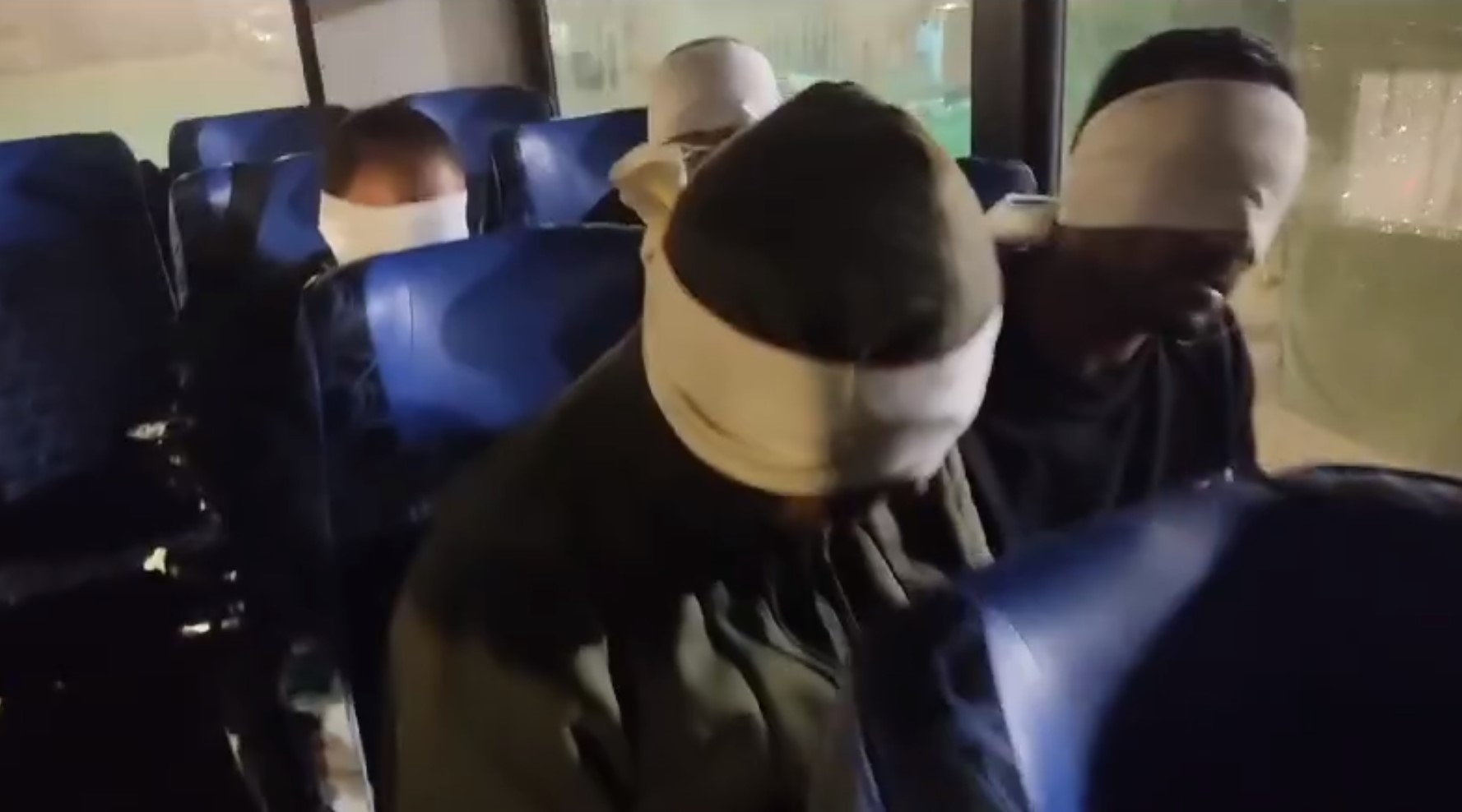 Blindfolded men sit on a bus and repeat Hebrew phrases, in footage shared on a far-right Israeli social media channel on 30 January 2024 (Telegram/Screengrab)