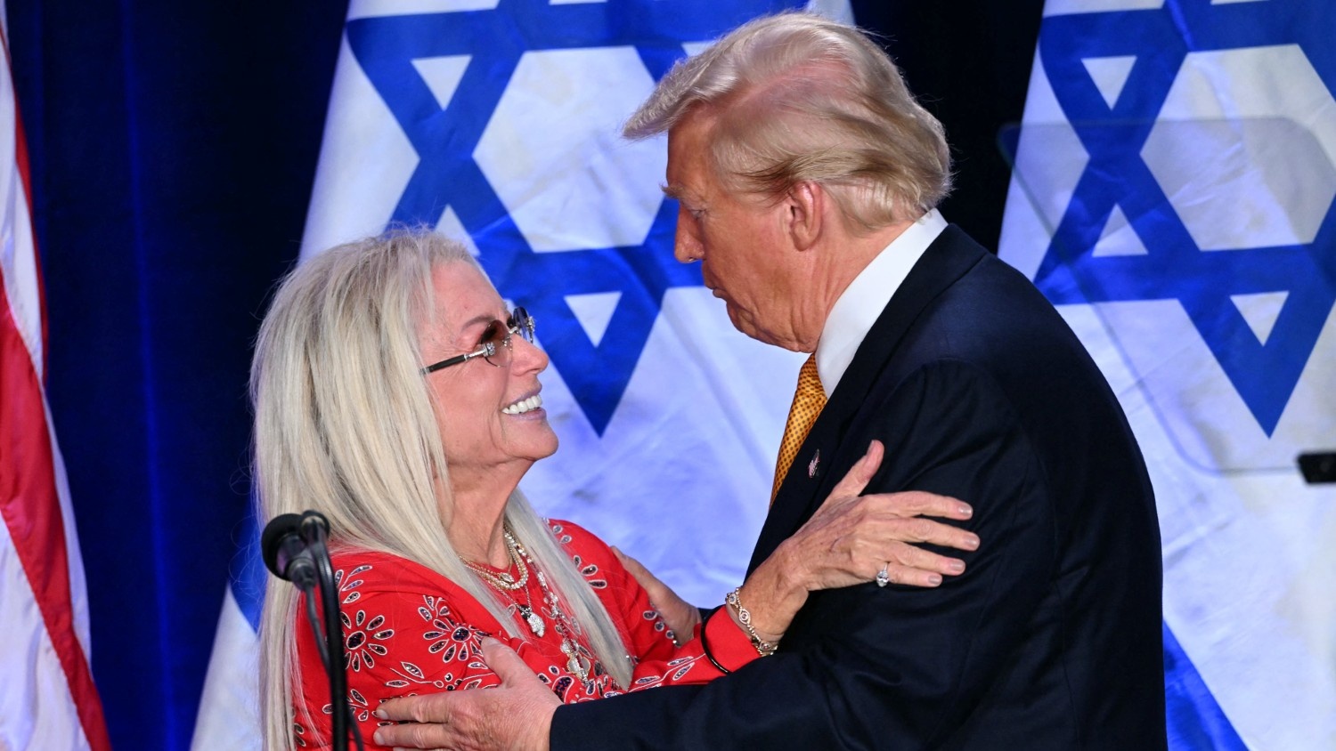 President-elect Donald Trump embraces megadonor Miriam Adelson before speaking at the Israeli-American Council National Summit in Washington, DC, on 19 September 2024.