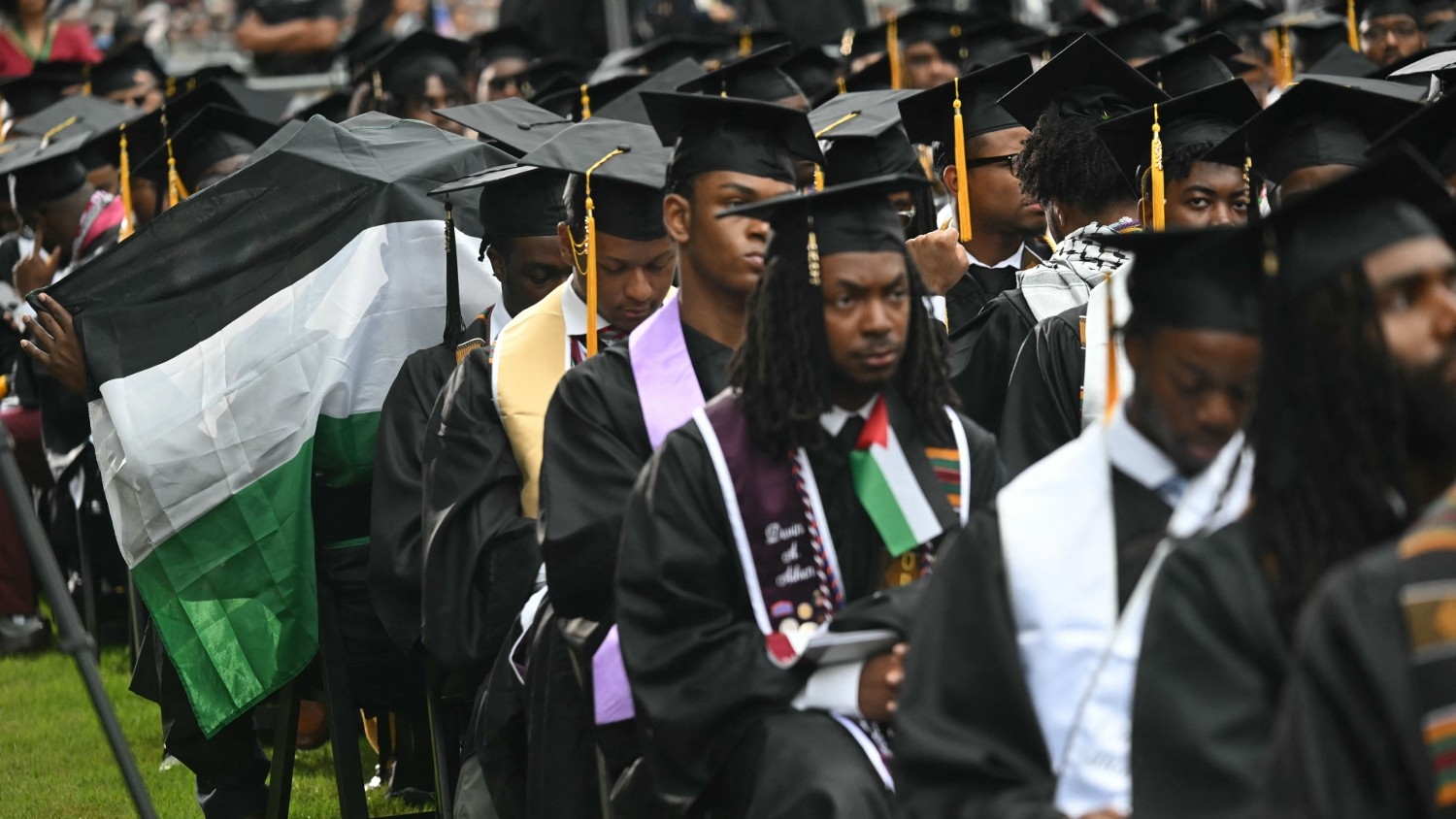 A graduating student holds a Palestinian flag as he turns his back on US President Joe Biden as he delivers a commencement address during Morehouse College's graduation ceremony in Atlanta, Georgia on 19 May 2024.