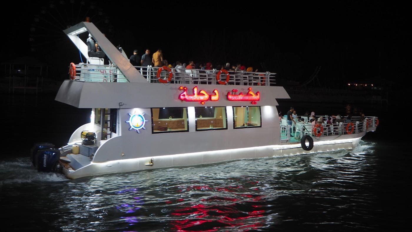 Les promenades nocturnes sur des bateaux illuminés sont une activité prisée des visiteurs du quartier d’al-Ghabaat, à Mossoul (MEE/Tom Westcott)