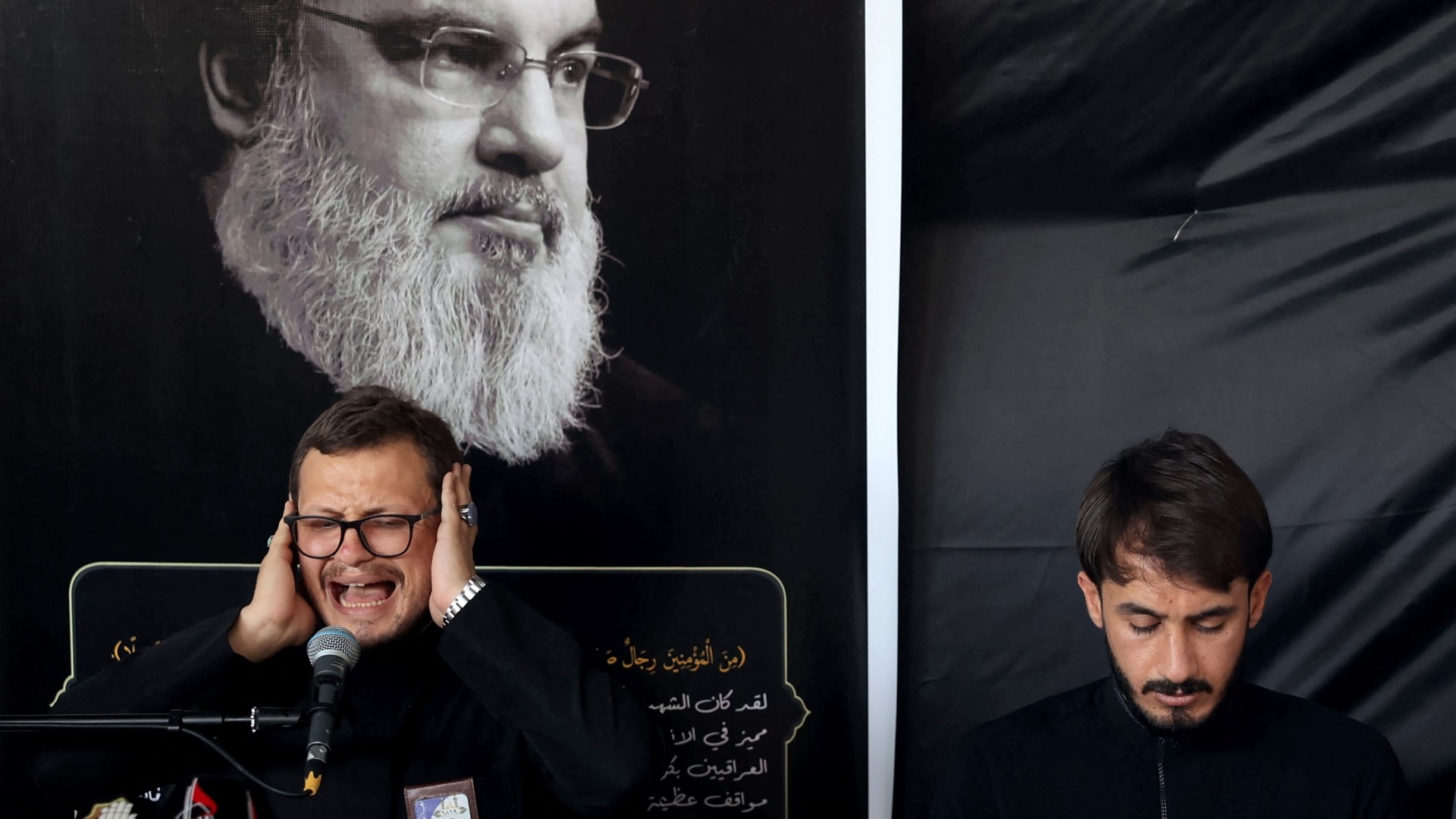 A man recites verses from the Quran during a memorial service for Hassan Nasrallah, in Iraq's Karbala on 29 September (AFP/Mohammed Sawaf)