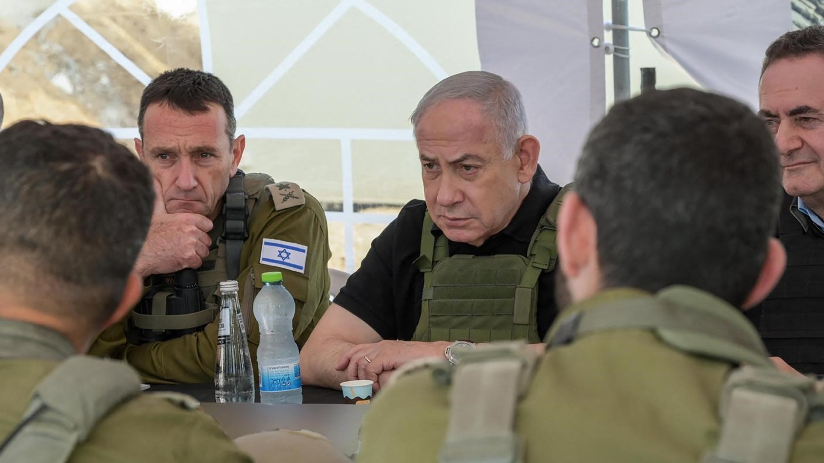 Israel's Prime Minister Benjamin Netanyahu (R), Defence Minister Israel Katz (R) and army Chief-of-Staff Herzi Halevi (L) during a briefing in the Netzarim Corridor, Israel's main military supply route which carves the Gaza Strip in two just south of Gaza City, on 19 November 2024 (AFP)