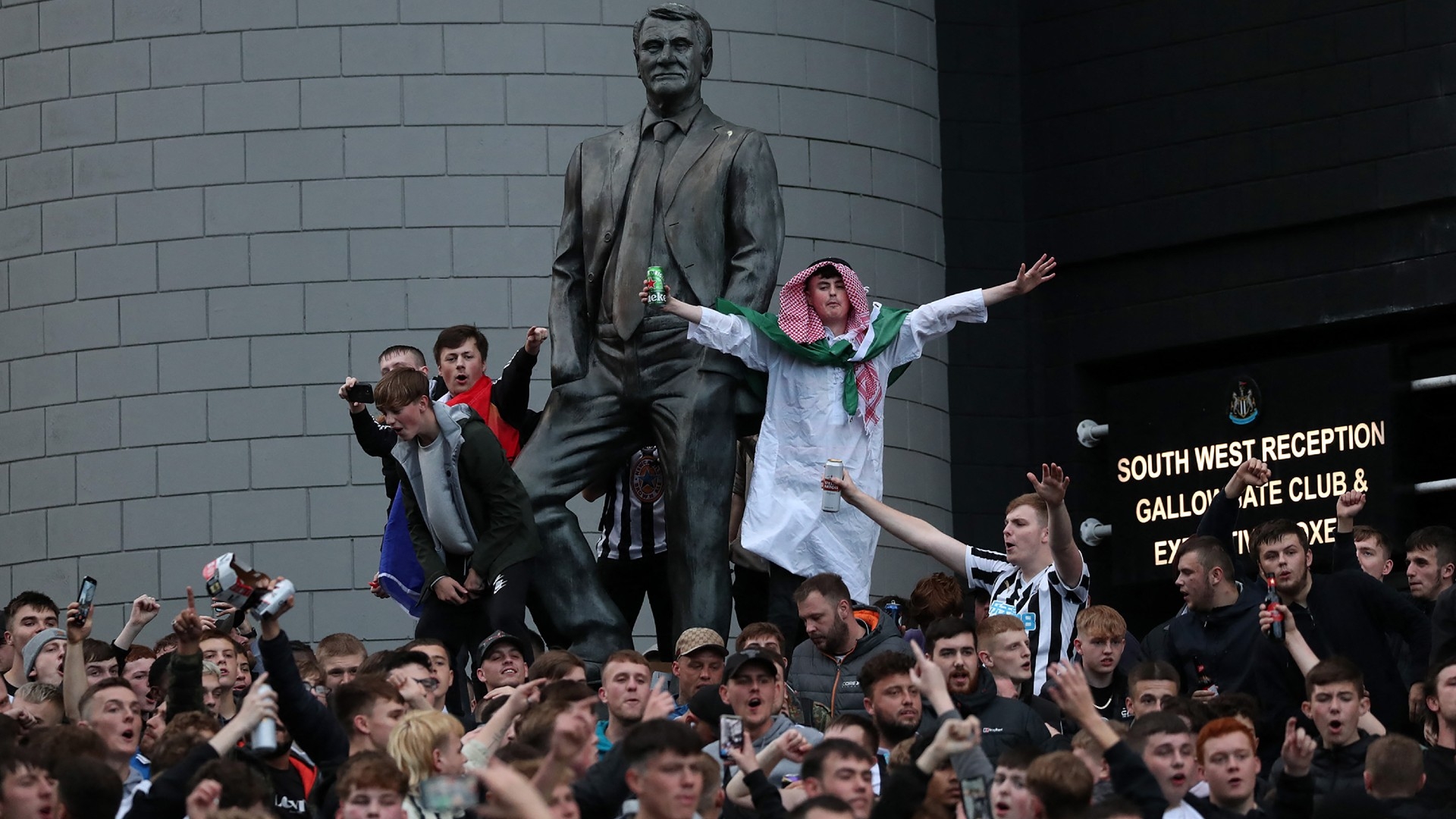 Newcastle United supporters celebrate a Saudi-led consortium taking over their club in Newcastle, England on 7 October 2021 (AFP)