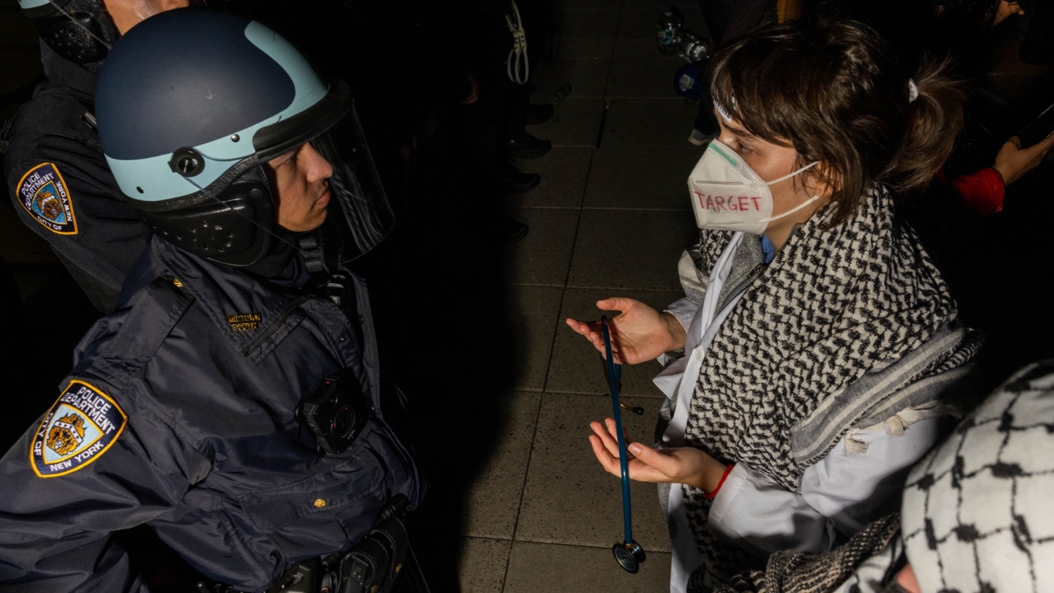 A pro-Palestinian protester holds a stethoscope as they face NYPD officers during a protest on the campus of New York University in New York on 22 April 2024.