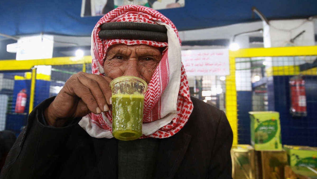 Un Jordanien goûte de l’huile d’olive fraîchement pressée dans une presse automatique de Mahis, à l’ouest de la capitale Amman, le 20 novembre 2020 (AFP)