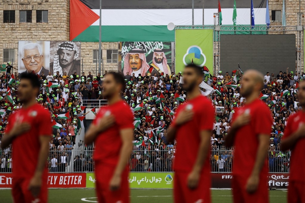 ​​​​​​​L’équipe nationale palestinienne de football chante son hymne national lors d’un match de qualification pour la Coupe du monde 2022 entre la Palestine et l’Arabie saoudite en Cisjordanie occupée, le 15 octobre 2019 (AFP/Ahmad Gharabli)
