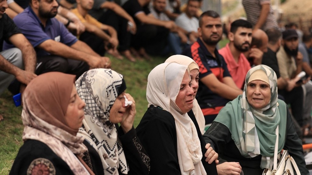 Palestinians mourn the death of their relatives following an Israeli airstrike on the refugee camp of Jabalia in the Gaza Strip on 9 October 2023 (AFP)