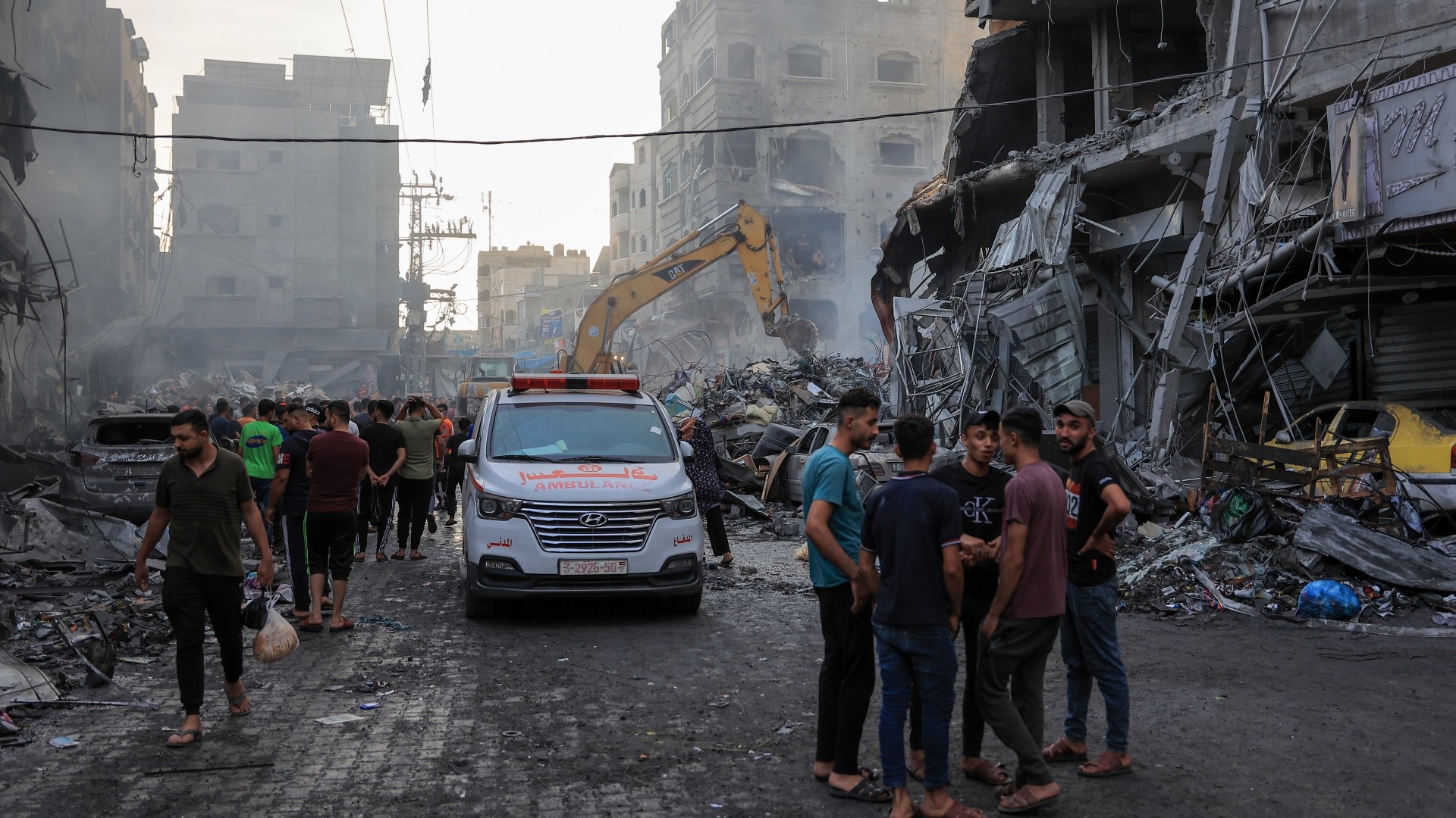 Des Palestiniens cherchent des survivants après une frappe aérienne israélienne sur des bâtiments de la bande de Gaza, le 9 octobre 2023 (MEE/Mohammed al-Hajjar)