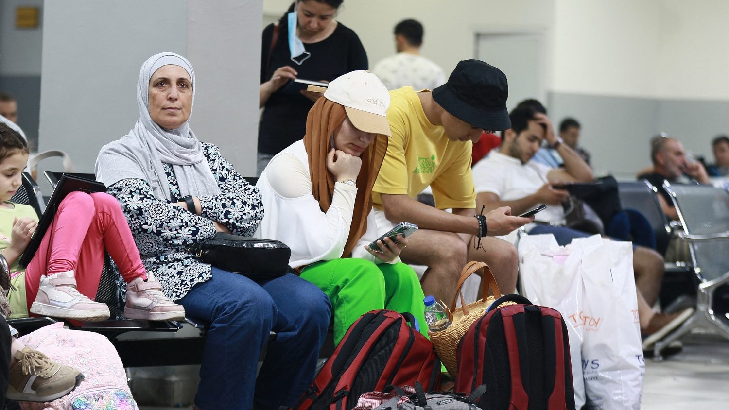 Passengers sit in a waiting room on the Jordanian side of the King Hussein Bridge (also known as Allenby Bridge) crossing between the West Bank and Jordan on 19 July 2022.