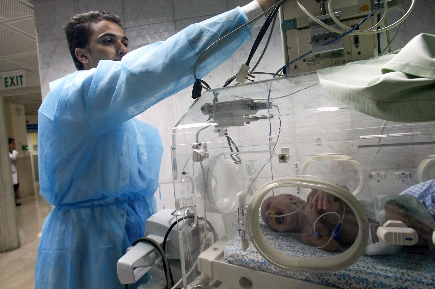 Un soignant palestinien fixe les tubulures d’une couveuse à l’hôpital al-Makassed de Jérusalem-Est occupée (AFP)