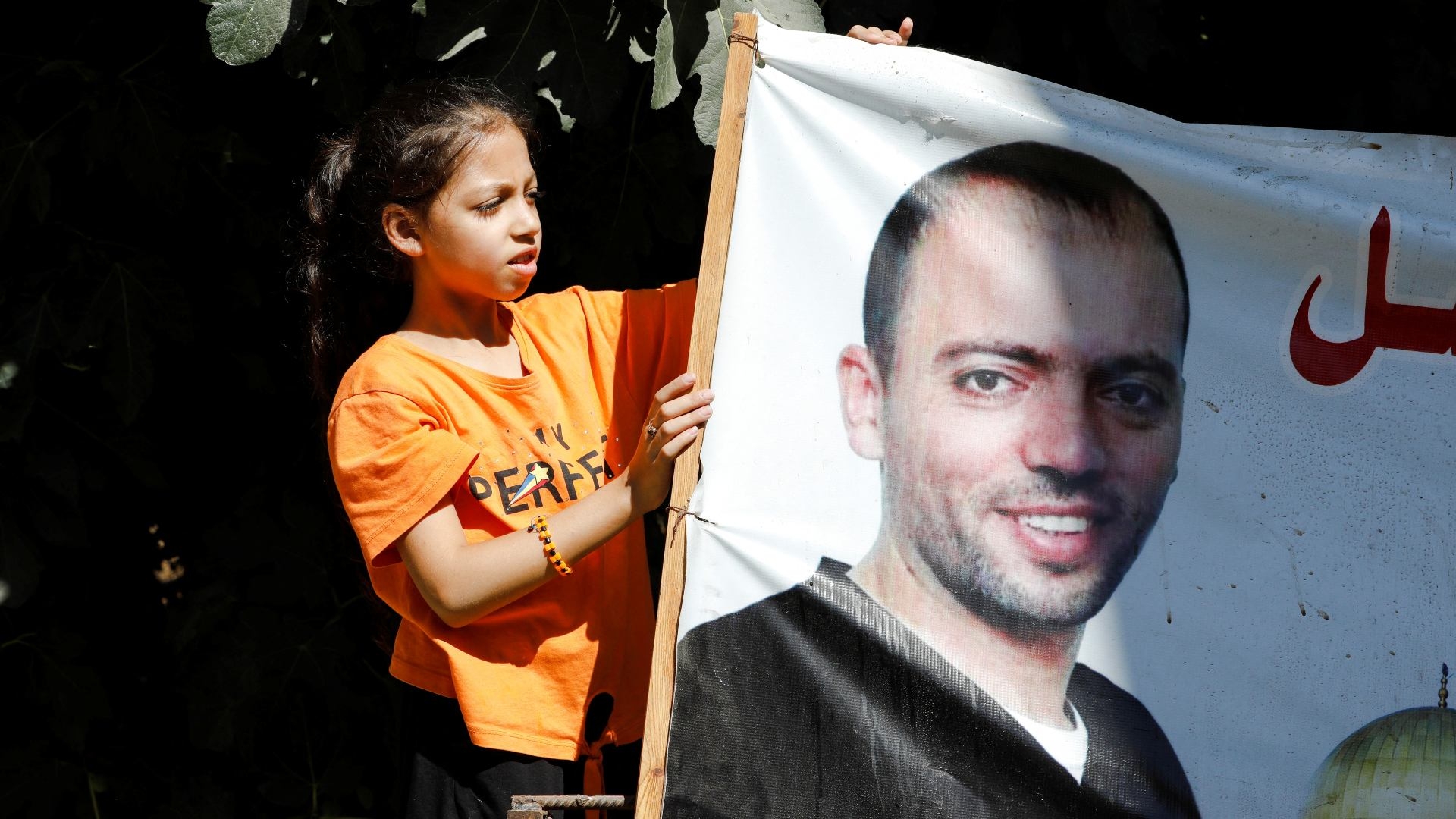 Palestinian prisoner Khalil Awawdeh's daugher looks at her father's picture at their house in Idhna, near Hebron, in the Israeli-occupied West Bank on 23 August 2022.