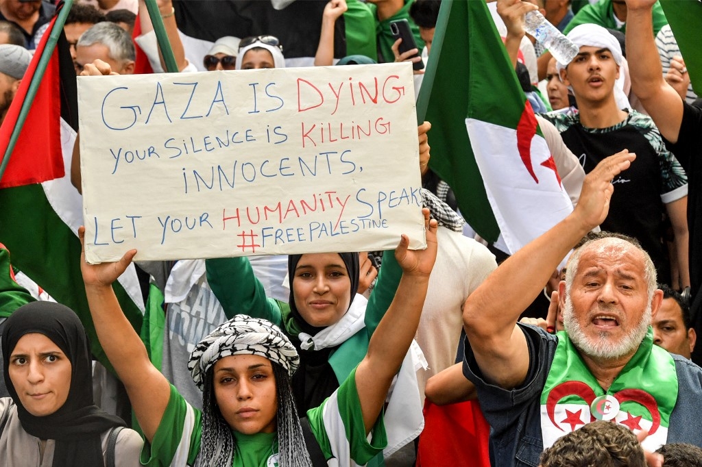 « Gaza est en train de mourir. Votre silence tue des innocents. Laissez votre humanité parler », peut-on lire sur la pancarte tenue dans la foule des manifestants, à Alger, le 19 octobre 2023 (AFP)