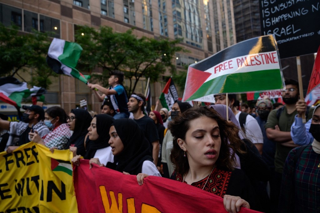 Demonstrators shout slogans and wave flags as they march during an 'emergency rally to defend Palestine' in Manhattan, New York on 15 June 2021.