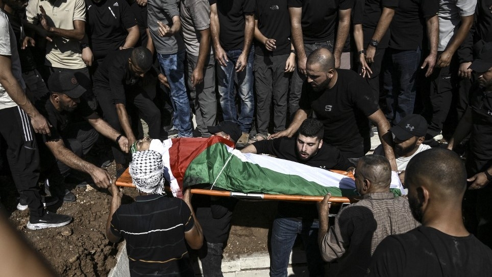 Palestinians gather during the burial of three men killed during an overnight raid by the Israeli army into the Jenin refugee camp, near the city of Jenin, in the northern Israeli occupied West Bank on 3 November 2023 (AFP)