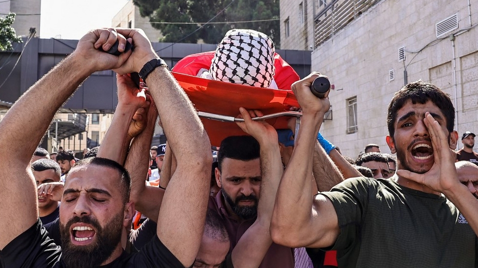 Mourners carry the body of a 13-year-old child killed in an Israeli raid in the occupied West Bank village of Deir Abu Mashal, during his funeral in Ramallah on 9 July 2024 (Zain Jaafar/AFP)