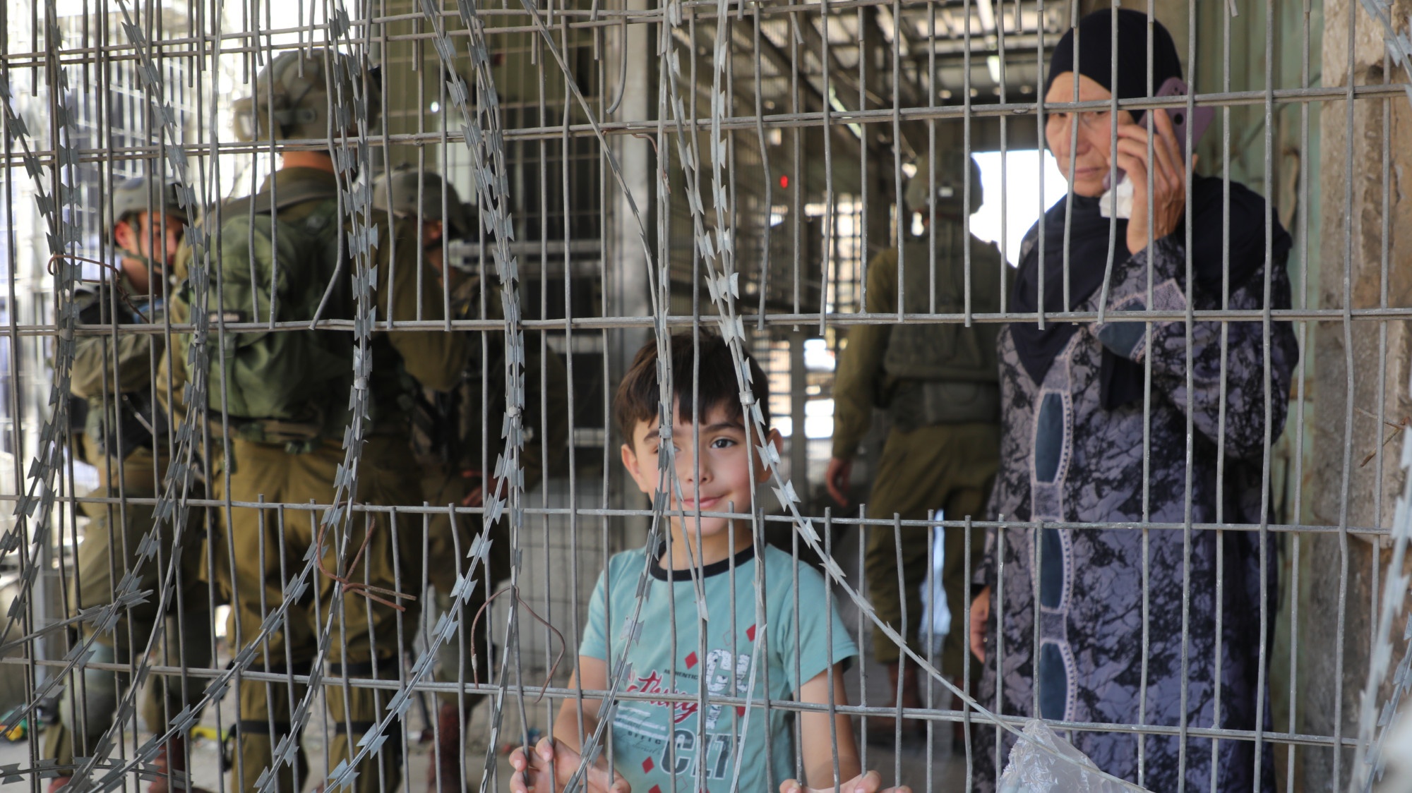 Palestinian child stands at an Israeli checkpoint in Hebron in the occupied West Bank (MEE/Mosab Shawar)