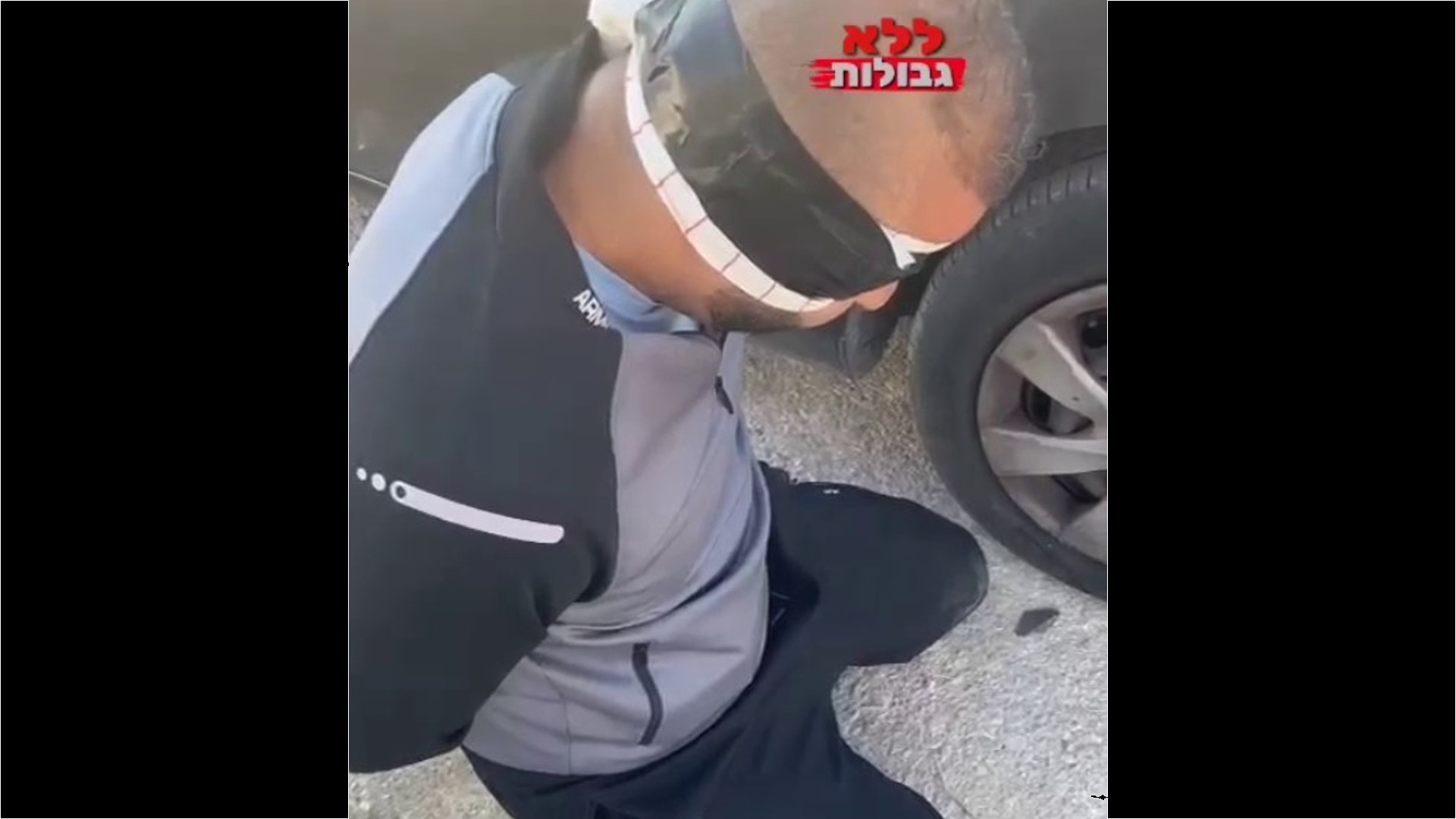 A video posted on a popular Israeli far-right Telegram channel shows a blindfolded and handcuffed man on his knees next to a car (Screengrab/Telegram)
