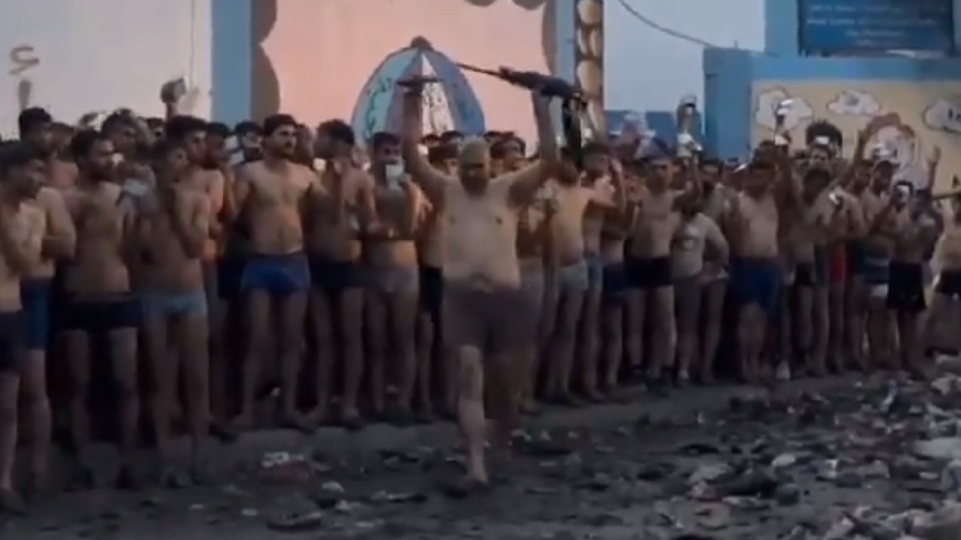 Video footage taken on 9 December 2023 in northern Gaza shows a Palestinian man forced to strip to his underwear holding a gun in the air (Screengrab)