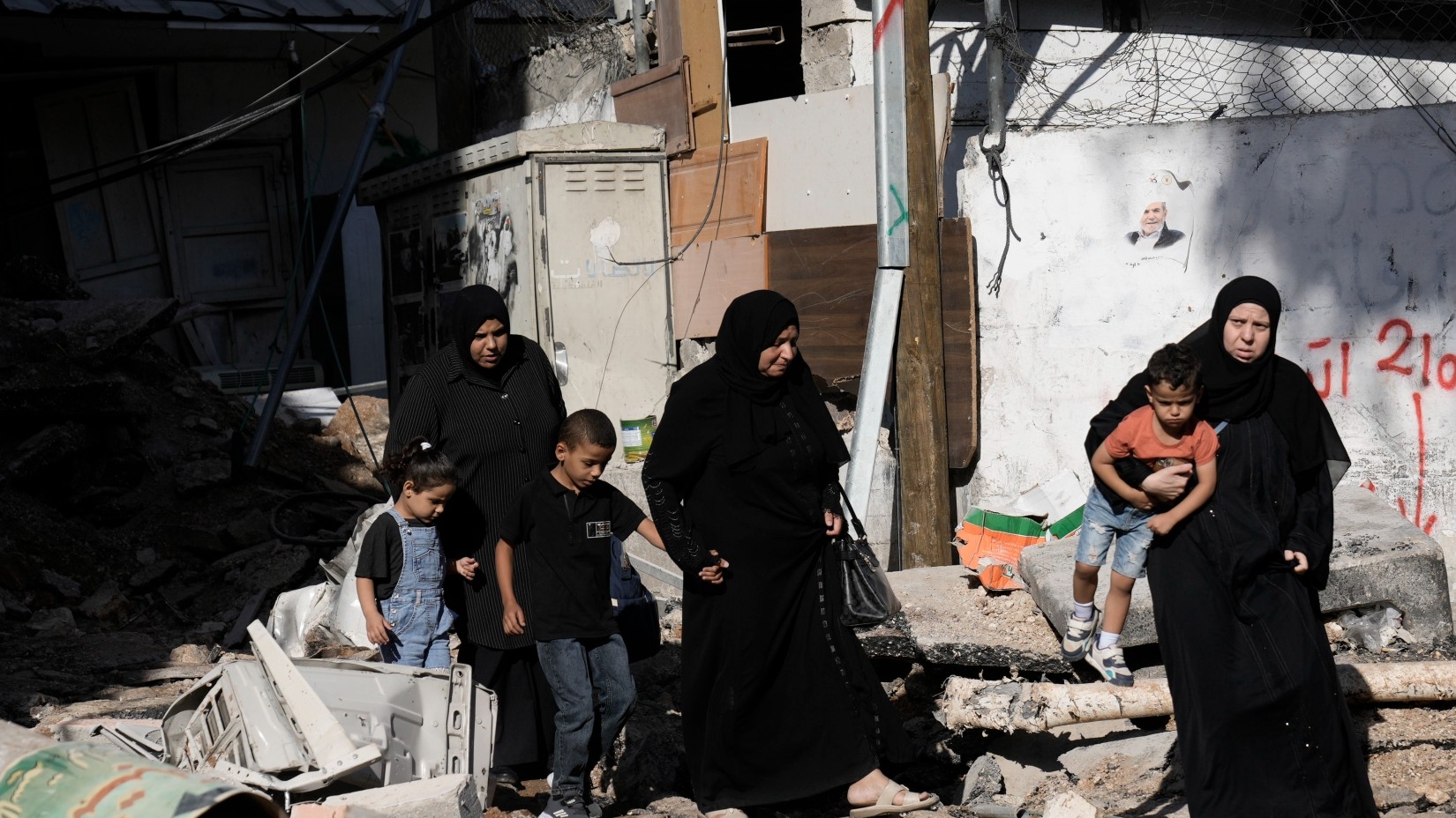 Palestinian women look at destruction after an Israeli army raid on a Palestinian refugee camp, Nur Shams, in the West Bank, 20 October 2023 (AP)