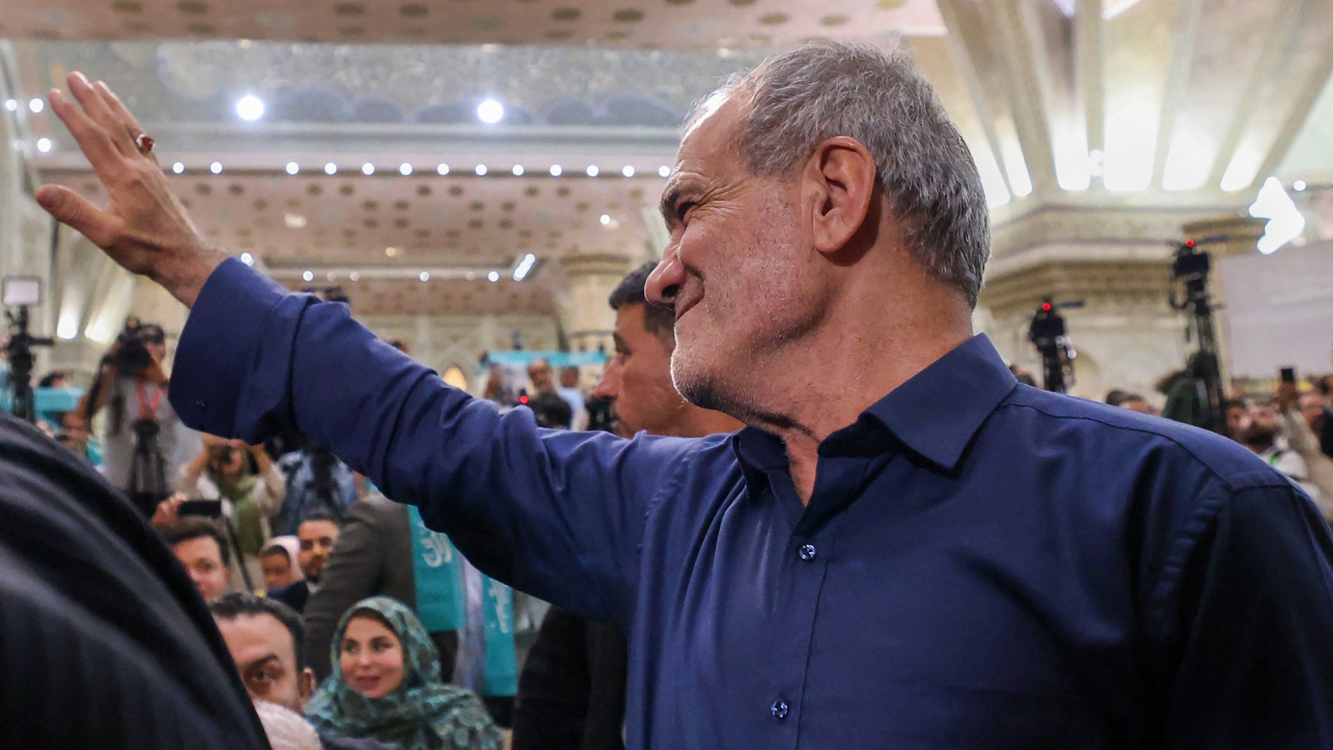 Newly elected Iranian President Masoud Pezeshkian waves to supporters as he arrives at the shrine of the Islamic Republic's founder Ayatollah Ruhollah Khomeini in Tehran on 6 July (AFP/Atta Kenare)