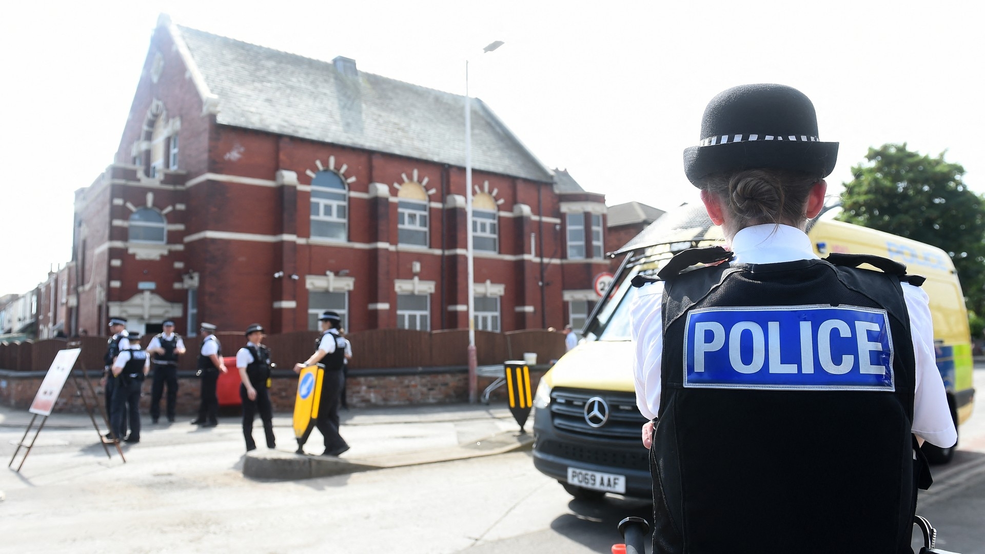 Police officers stand guard outside the Southport Islamic Society Mosque in Southport, northwest England, on 31 July 2024 (AFP/Peter Powell)