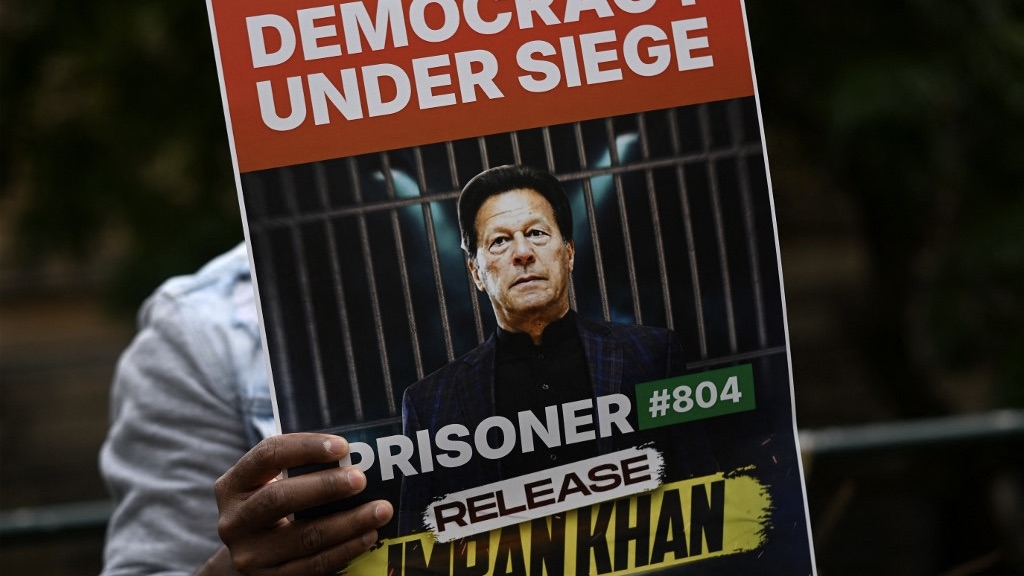 A supporter of Pakistan's jailed former prime minister, Imran Khan, holds a placard during a protest demanding his release, in Sydney on 4 August 2024 (Saeed Khan/AFP)