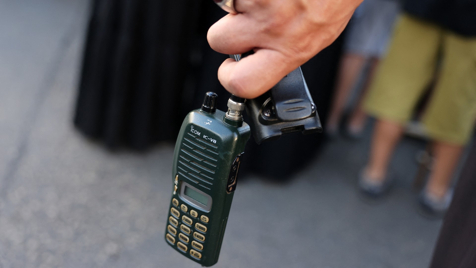 A man holds a radio device after he removed the battery during the Hezbollah funeral on 18 September (AFP)