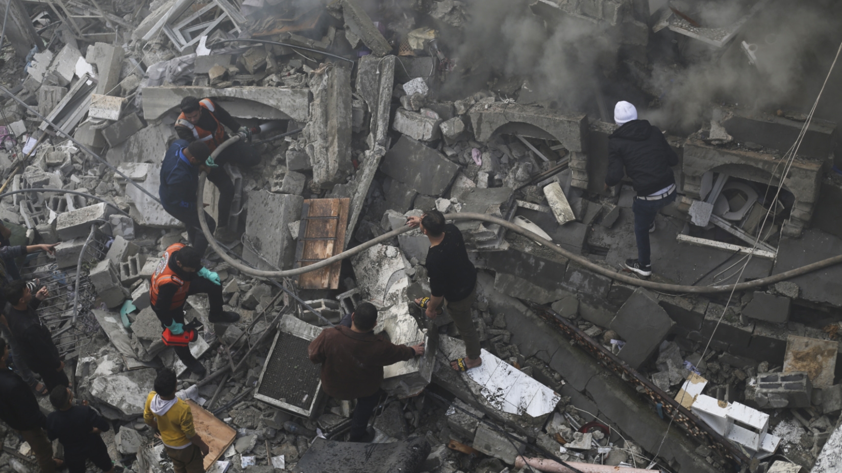 Palestinians search for survivors after an Israeli airstrike destroyed a building in Rafah