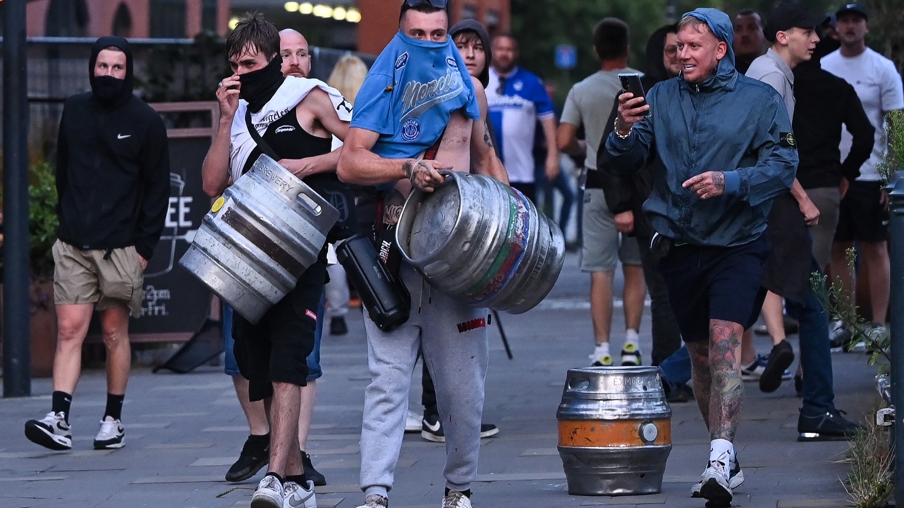 Men carry beer kegs during unrest in the English city of Bristol on 3 August (AFP/Justin Tallis)