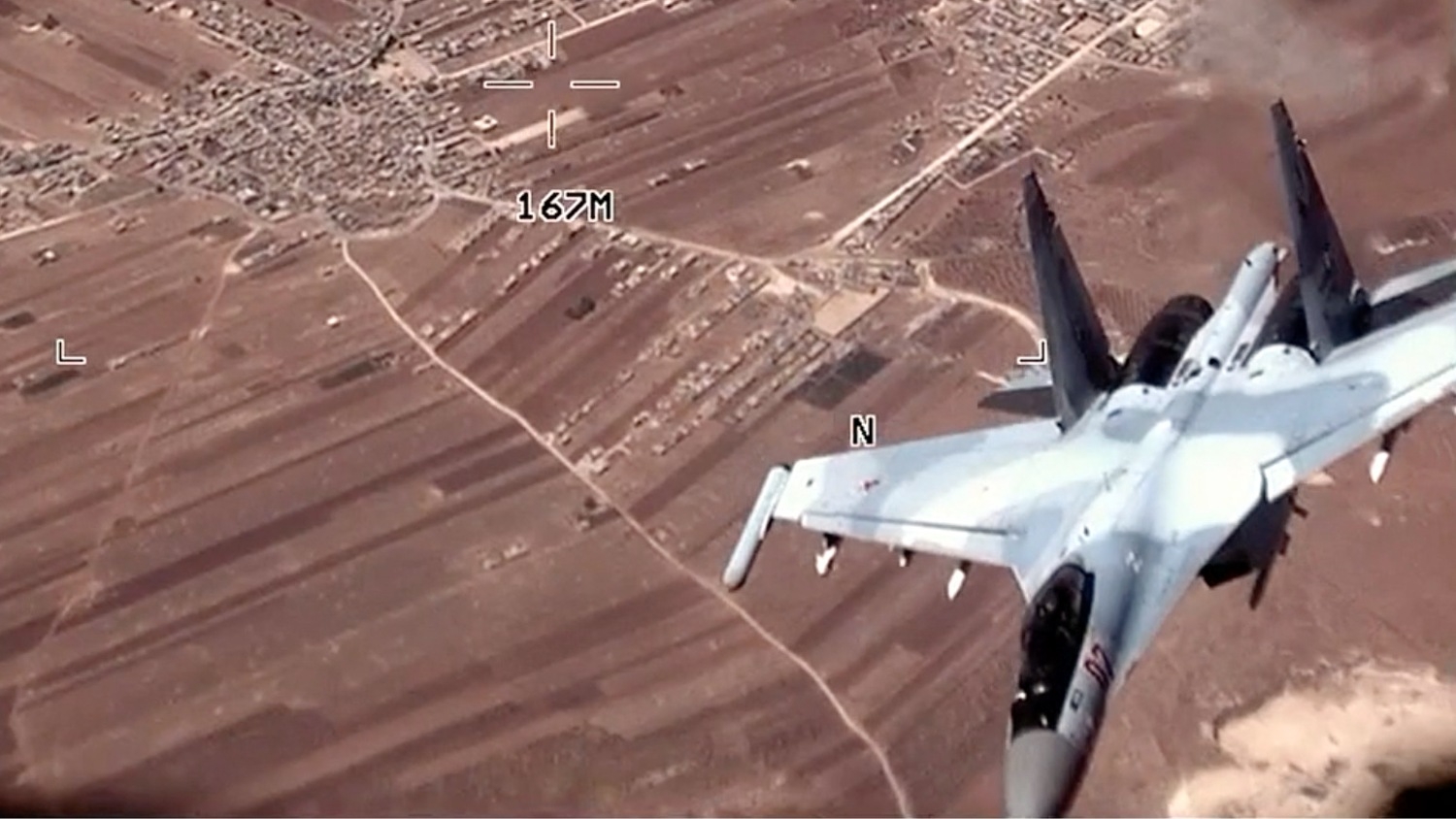 In this image from a video released by the US Air Force, a Russian SU-35 flies near an American MQ-9 Reaper drone on 5 July 2023 over Syria.