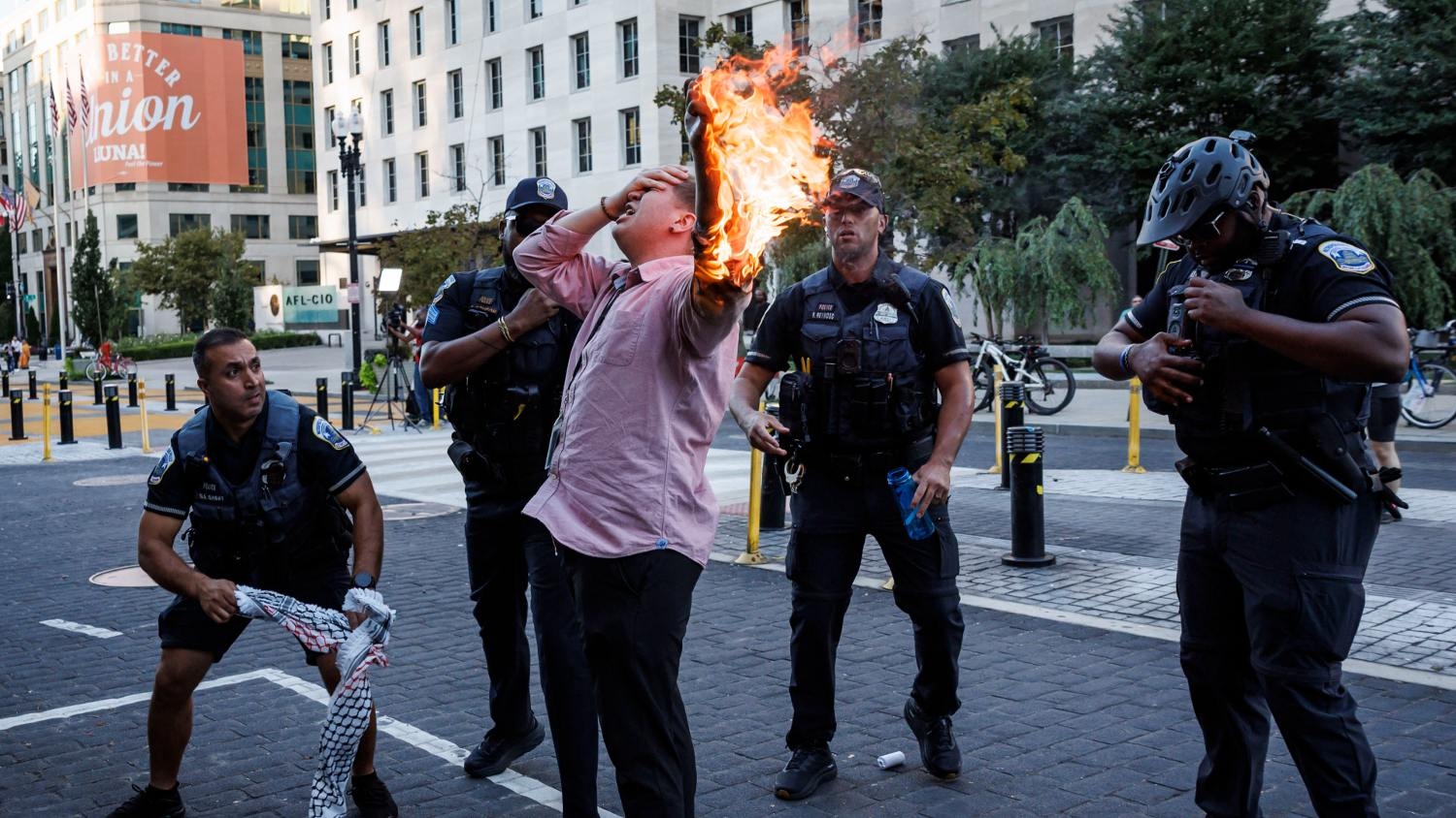 Police help Samuel Mena, who tried to set himself on fire, as people demonstrate to mark one year of Israel's war on Gaza near the White House in Washington DC on 5 October 2024.