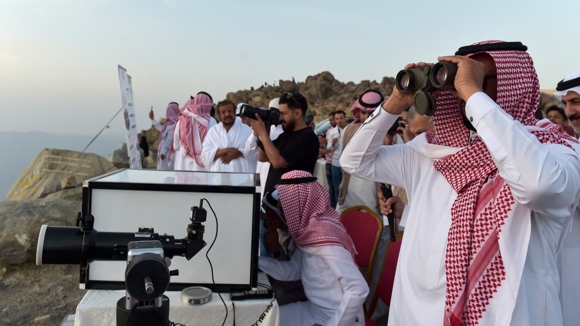 Saudis look at the sky to spot the crescent of the moon in the southwestern Saudi city of Taif (AFP/File photo)