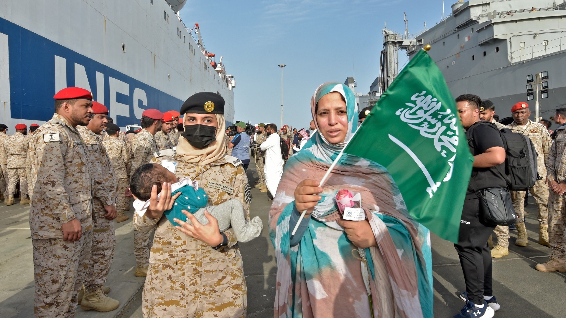 Members of the Saudi Navy Forces assist evacuees arriving at King Faisal navy base in Jeddah on 26 April 2023 (AFP)