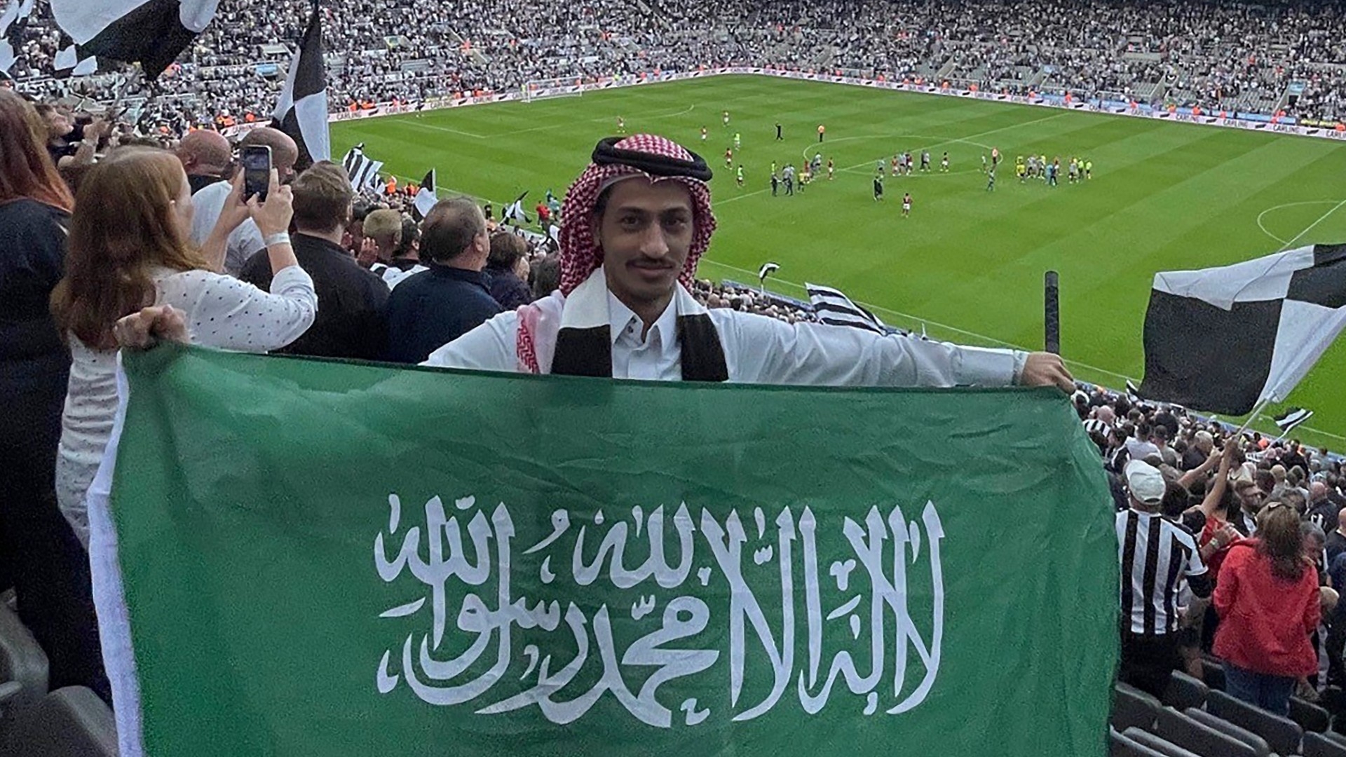 A Saudi Arabian fan carries the national flag during a Premier League football match at St James' Park in Newcastle-upon-Tyne on 6 August 2022 (AFP) 