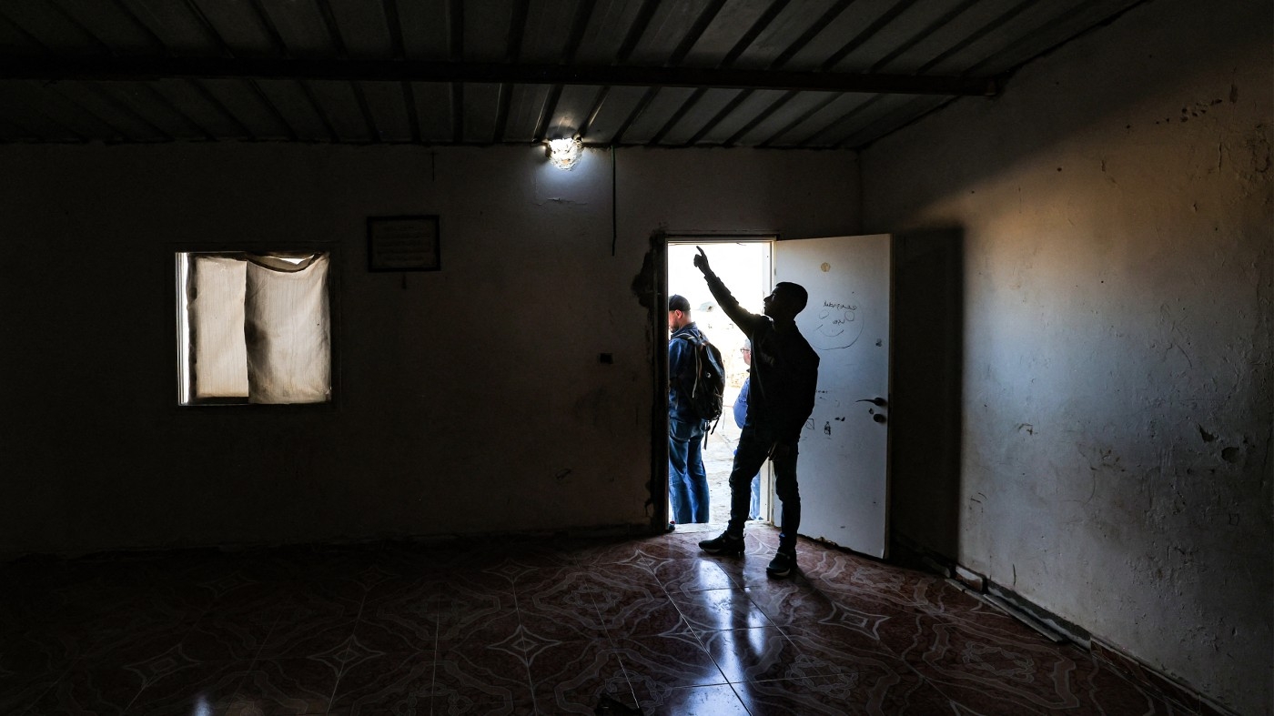 A relative points to a hole caused by a projectile that injured seven-year-old Bedouin girl Amina in her village, not recognised by Israeli authorities, in the southern Negev desert on 14 April 2024 (Ahmad Gharabli/AFP)