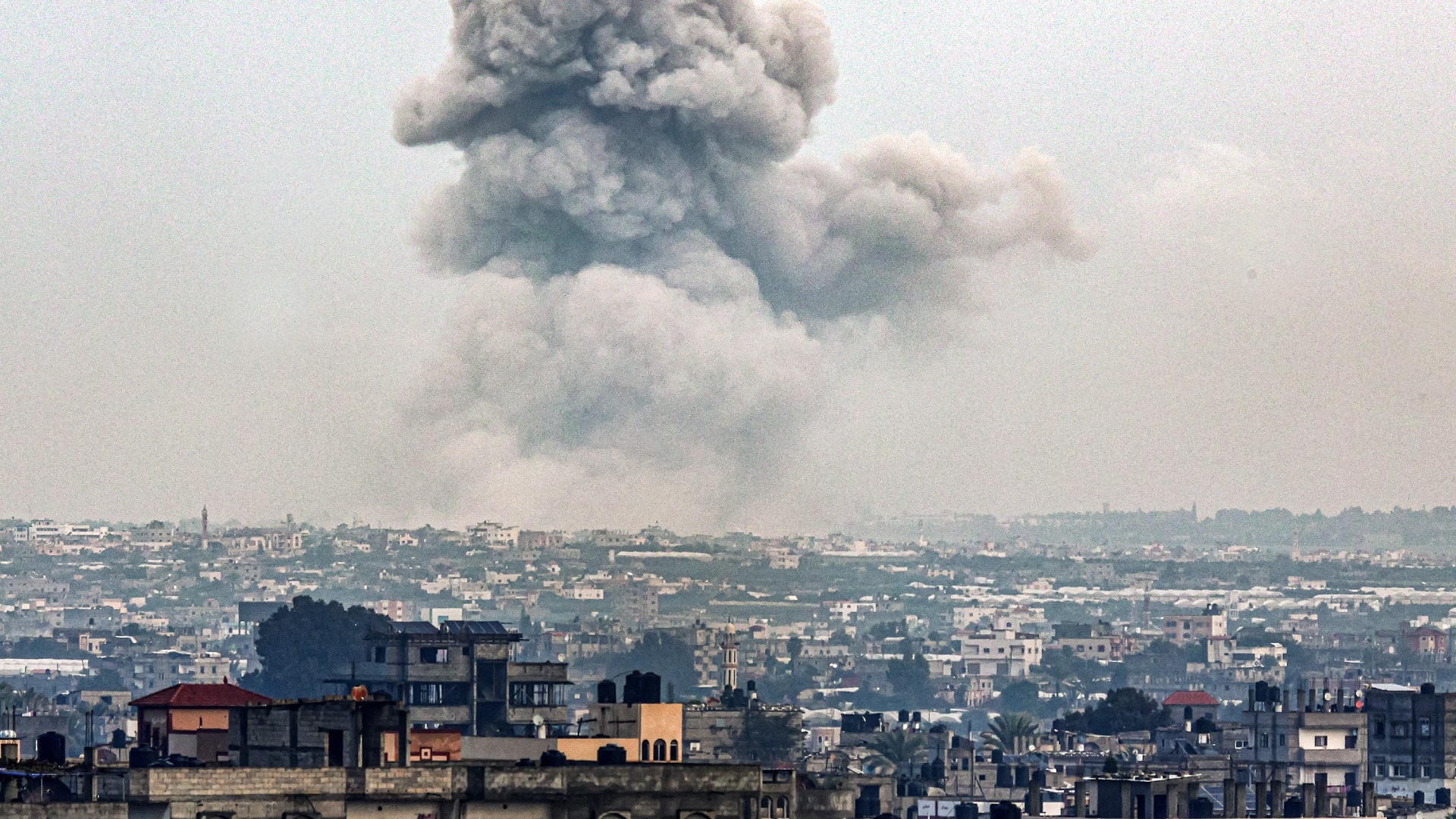 Smoke billows over Khan Younis from Rafah in the southern Gaza strip during Israeli bombardment on 2 January 2024 (AFP)