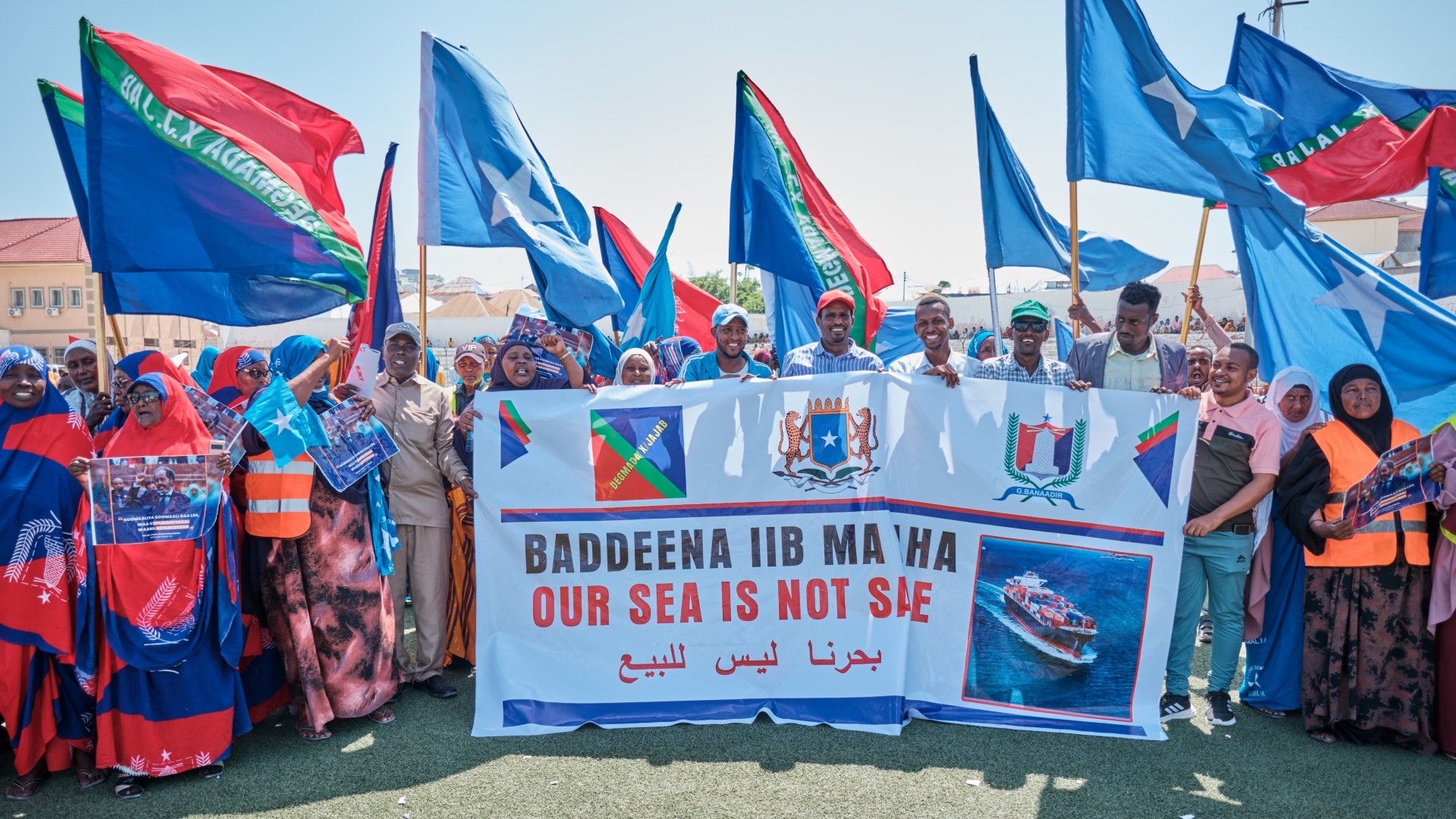 Demonstrators hold banners and flags during a demonstration in support of Somalia's government following the port deal signed between Ethiopia and the breakaway region of Somaliland at Eng Yariisow Stadium in Mogadishu on 3 January 2024 (AFP)