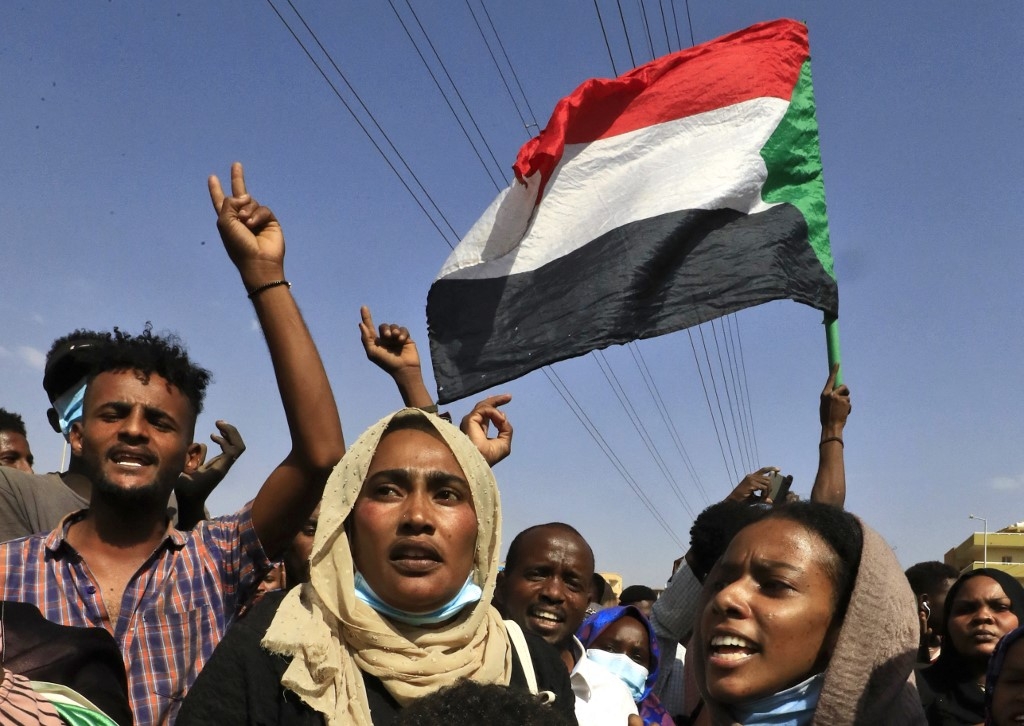 Sudanese protesters rally in Khartoum to denounce overnight detentions by the army of government members, on 25 October 2021.