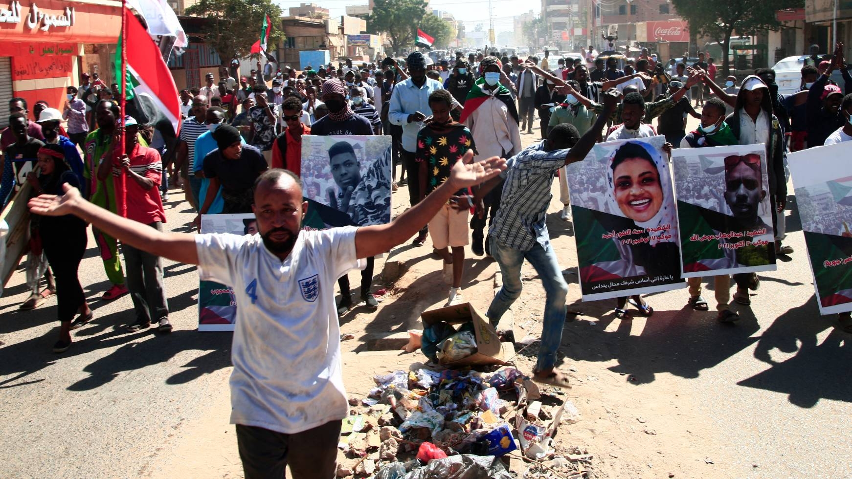 Sudanese demonstrators carry posters of killed protesters as they protest in the capital Khartoum against the army's 25 October coup, on 30 December 2021.