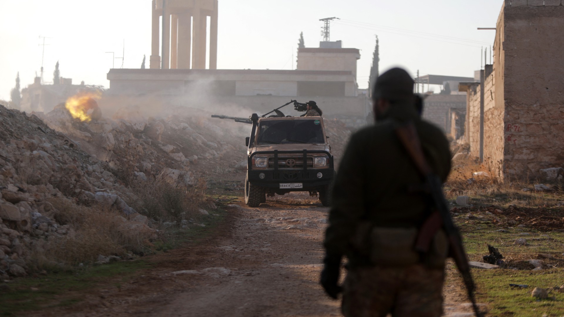 Fighters fire towards Syrian army troops in the Rashidin district on the outskirts of Aleppo on 29 November (Bakr Alkasem/AFP)