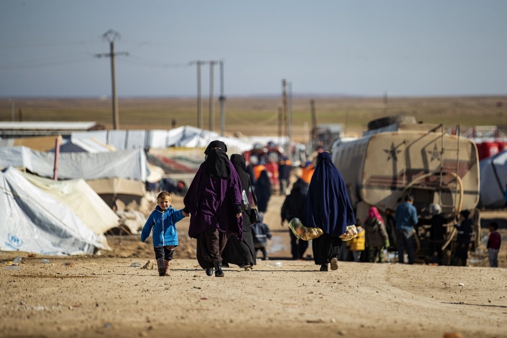 Women walk by with children in a main alley of the Kurdish-run al-Hol camp in Syria in January.