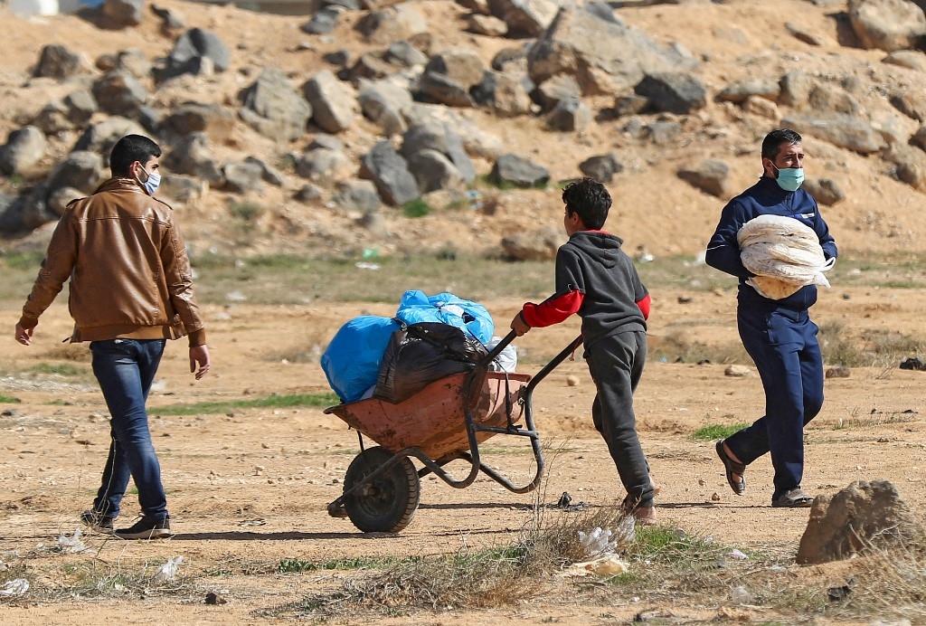 A Syrian refugee pushes a wheelbarrow at the Zaatari refugee camp, 80 kilometers (50 miles) north of the Jordanian capital Amman on 15 February 2021.