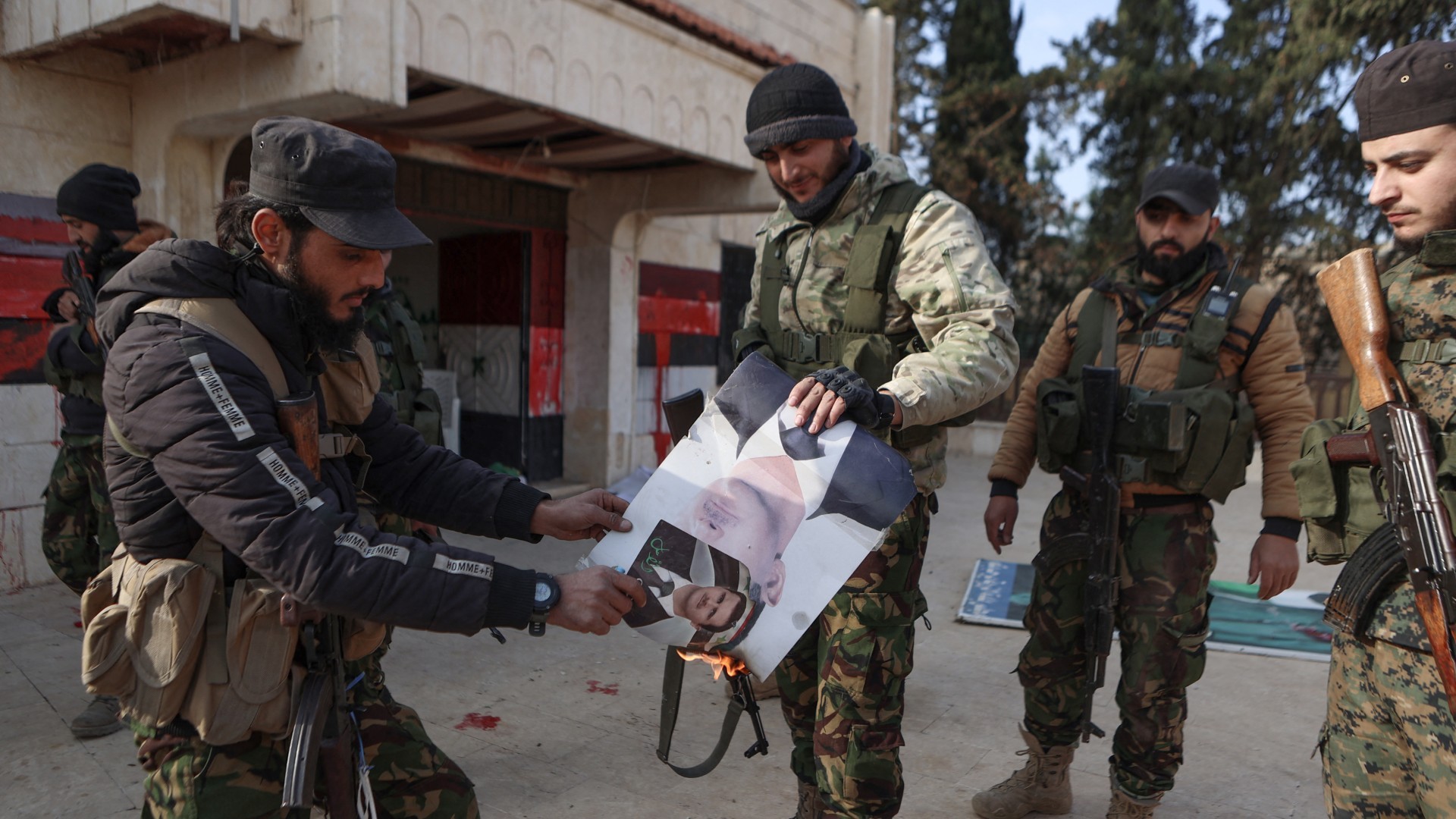 Fighters set alight a picture of Bashar al-Assad in the area of Zarbah on 29 November (Aaref Watad/AFP)