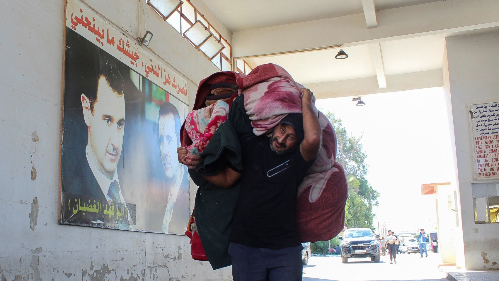 A Syrian man, who had been living in Lebanon but returned to Syria after Israel's war on Lebanon, carries his belongings at the Lebanon-Syria border crossing on 2 October 2024 (Reuters/Firas Makdesi)