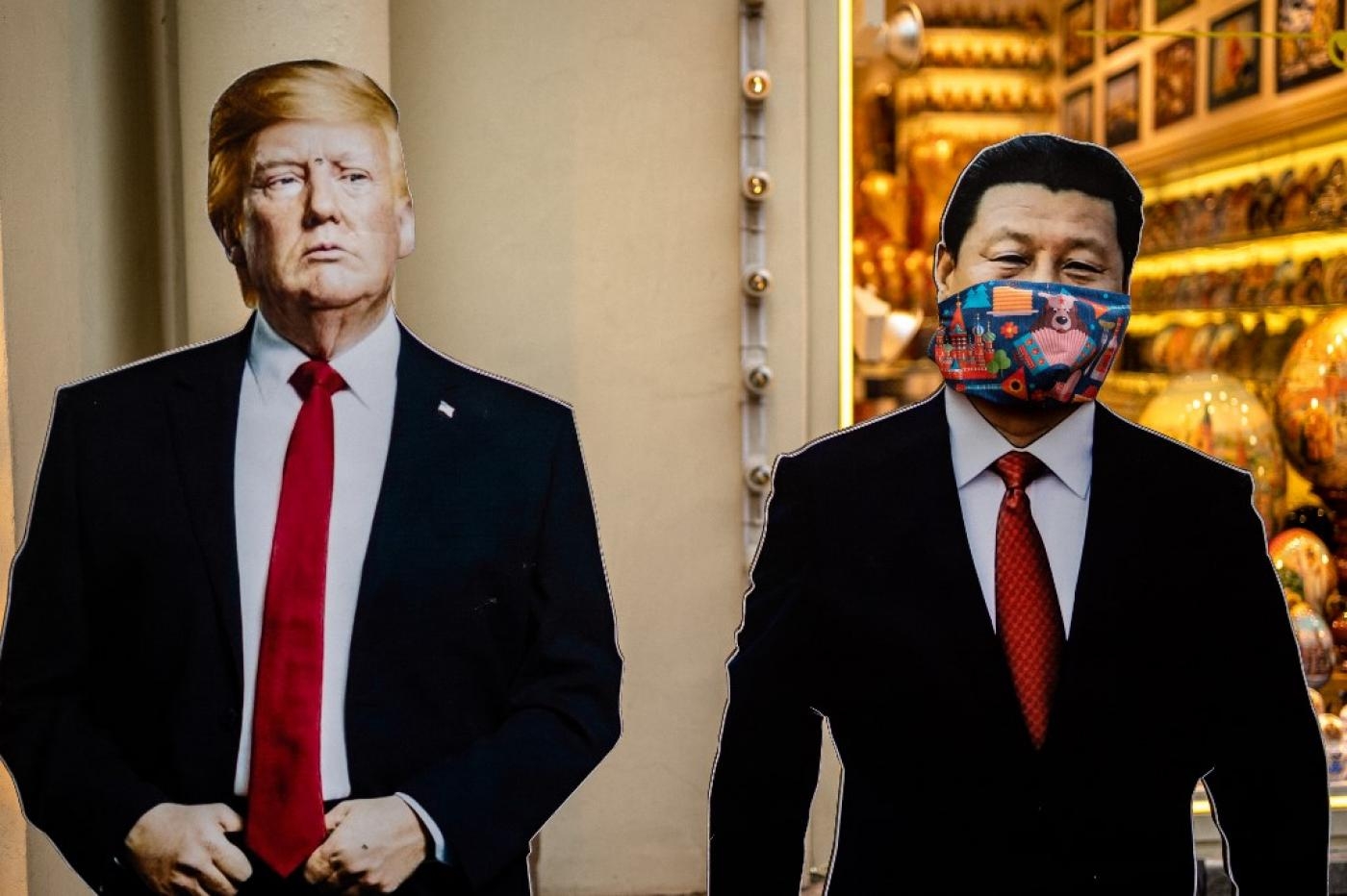 Des silhouettes en carton du président chinois Xi Jinping et du président américain Donald Trump devant une échoppe de souvenirs à Moscou, le 3 juin (AFP)